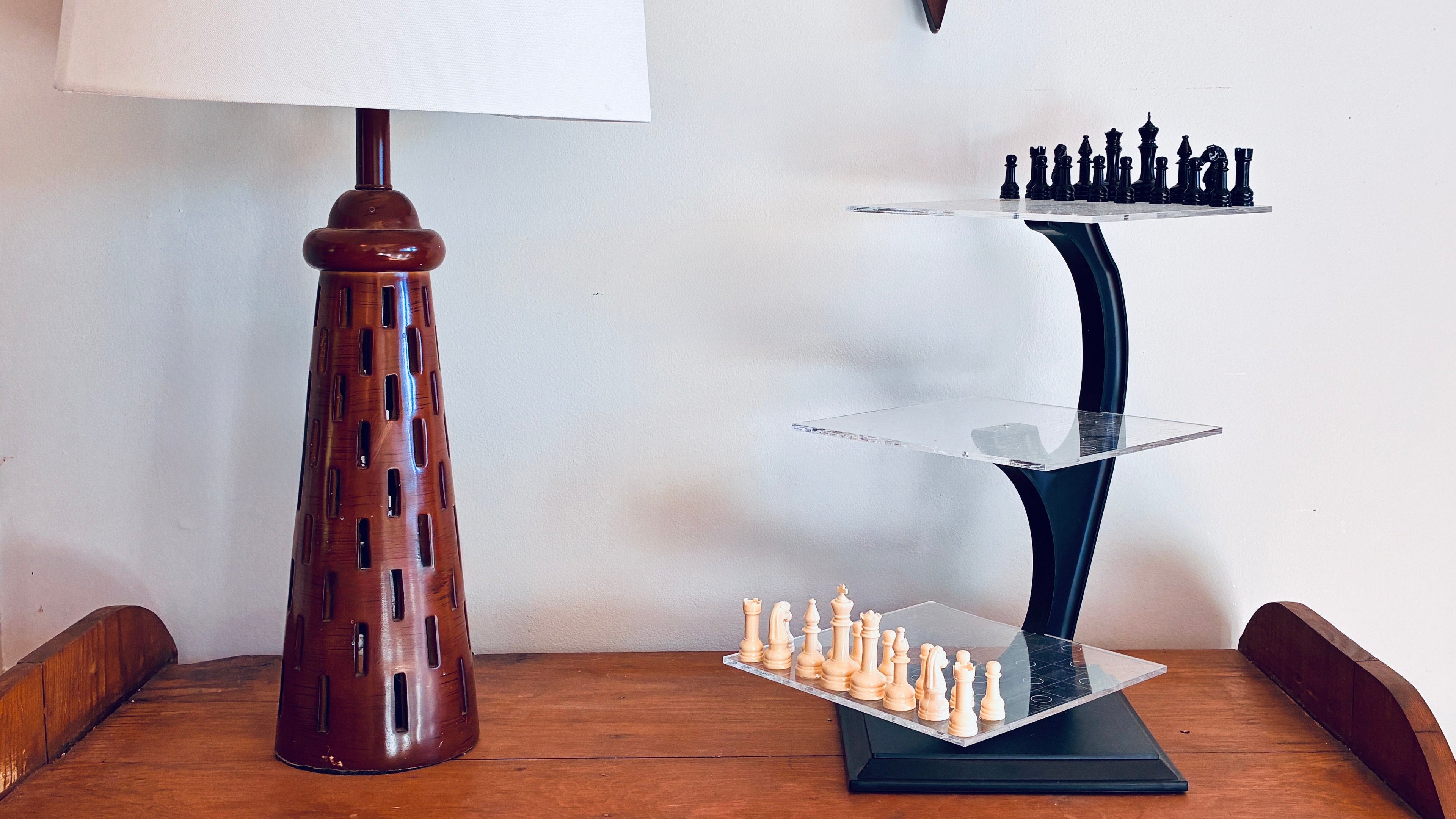 The Original 3D Chess Game on a shelf, next to a wooden lamp. 